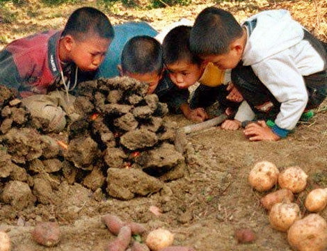 孩子们鼓动着腮帮子吹火