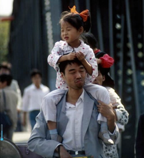 骑在父亲肩膀上的小女孩